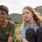 Environmental activists Vipulan Puvaneswaran, a French boy of Sri Lankan descent, and Bella Lack, an English girl, in a green, hilly landscape